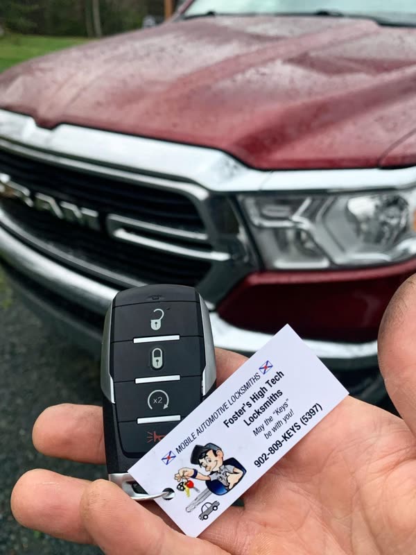 New Ram key fob held in front of a red Ram pickup truck
